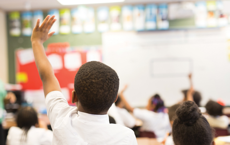 Charter Central Podcast cover image. Student raising their hand in class.