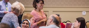 Photo of staff talking with attendees at the Center's annual conference.