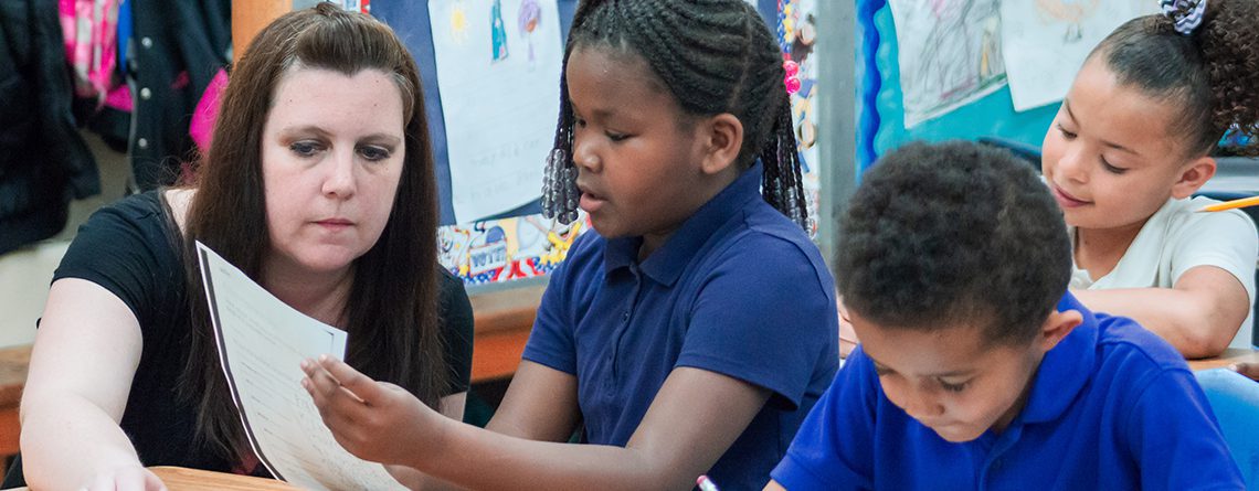 Teacher from Mid-Michigan Leadership Academy assisting student with classwork.